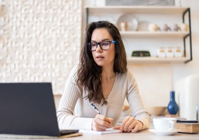 A learner is taking notes during an online nursing course