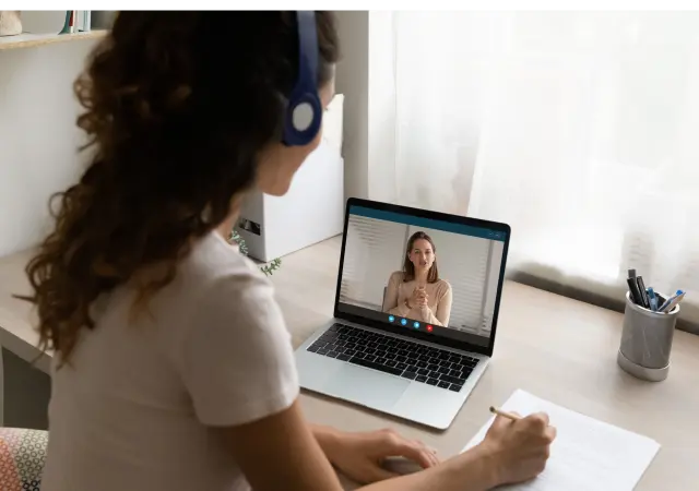 A learner advancing her nursing career by taking notes during an online nursing program