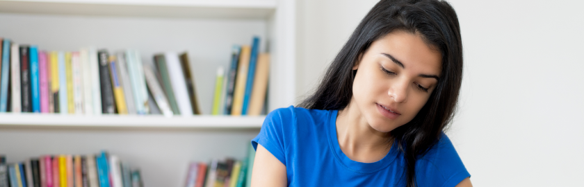 An online nursing program learner taking notes during a class